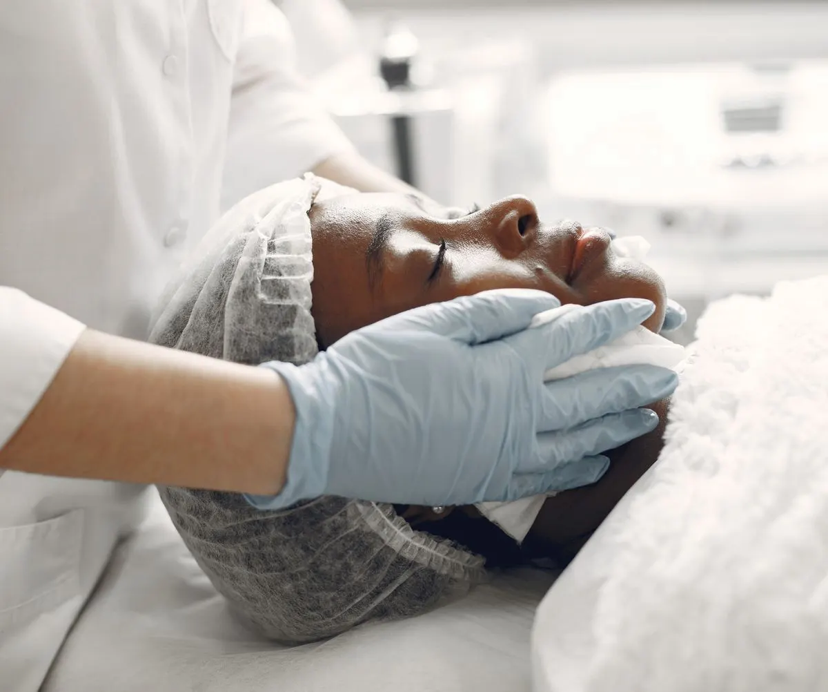 A clinician treating a client under a lamp.